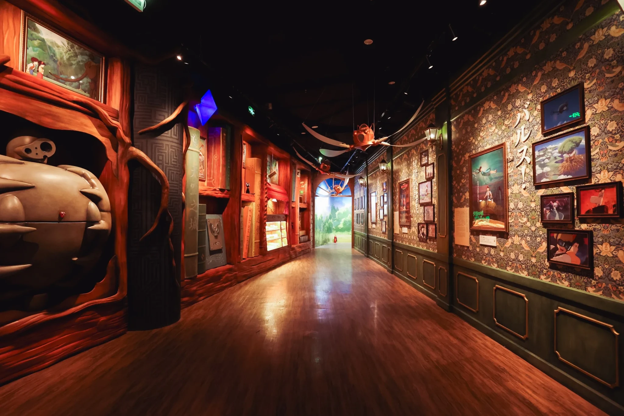 An immersive corridor with red-lit architecture, character sculptures, and framed film scenes along both walls