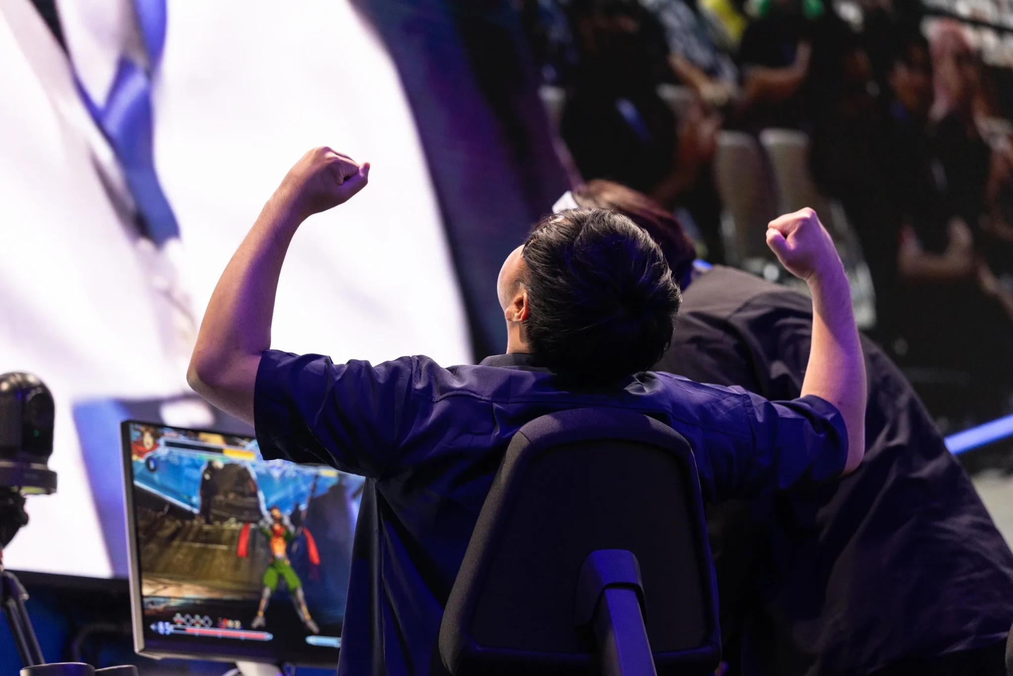 A player raises both clenched fists in celebration during a match at Evo