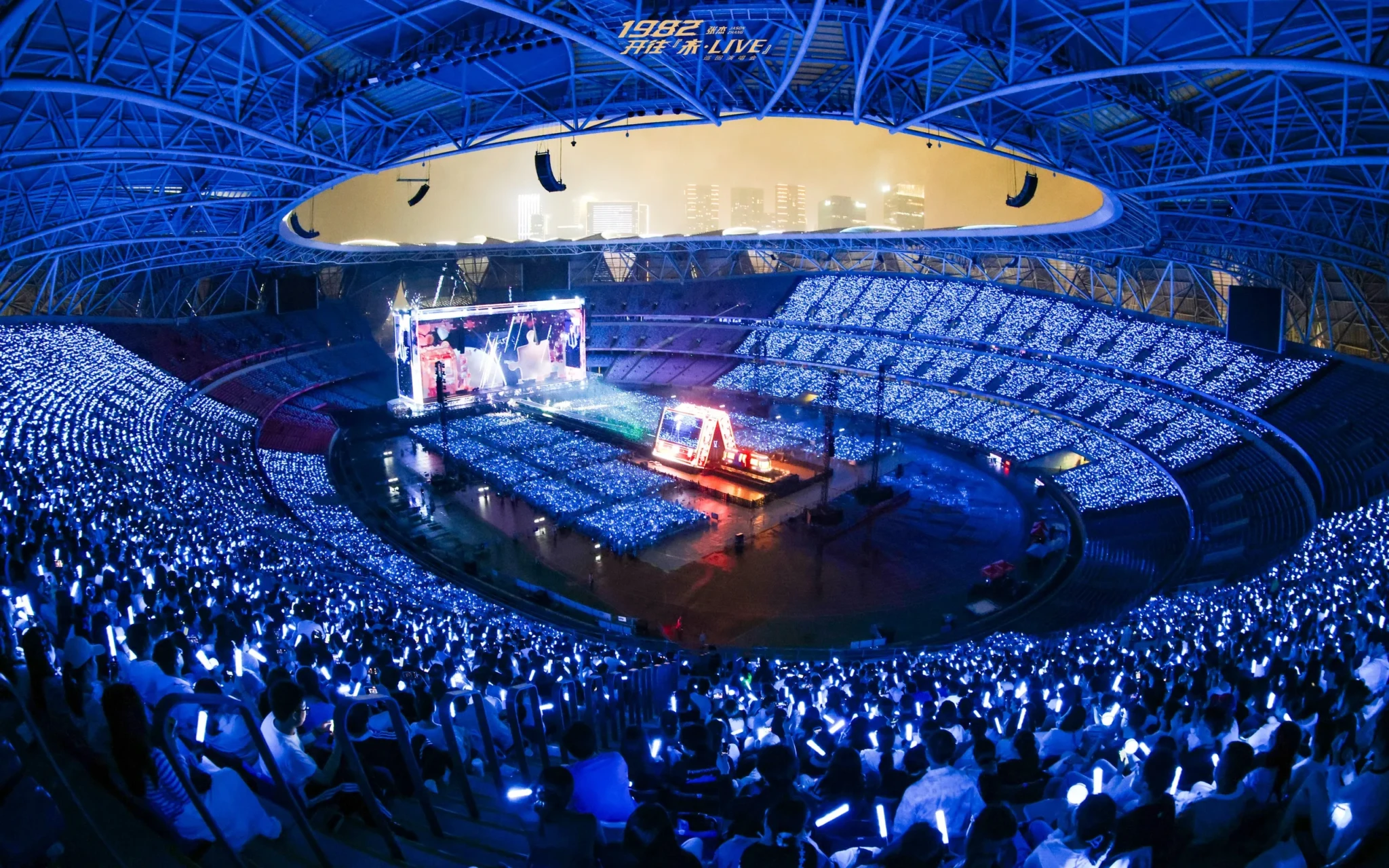 Jason Zhang's Hangzhou stage surrounded by a crowd of phone lights under a curved gold ceiling