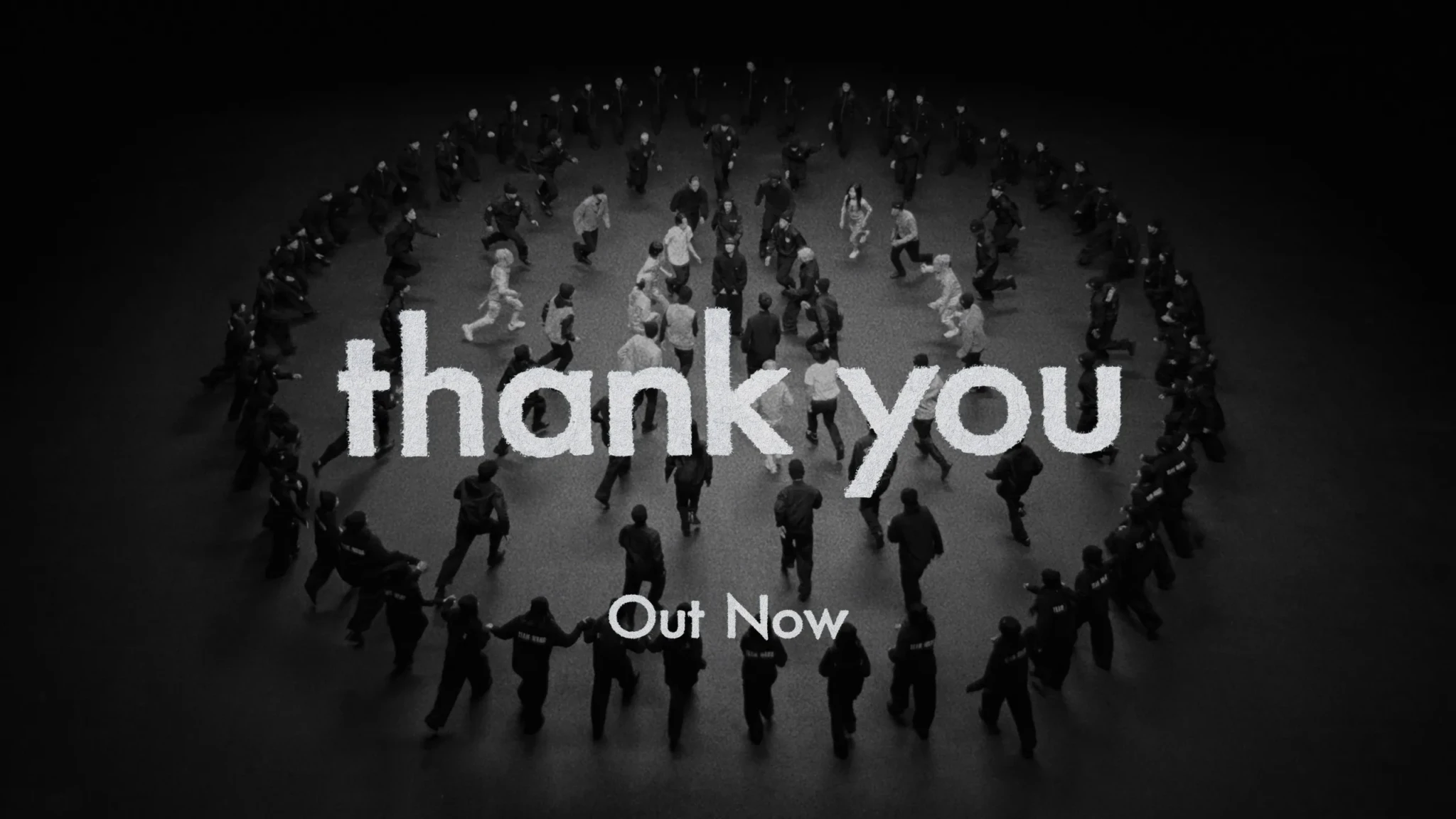 Aerial view of people walking on a gray surface with white text reading 