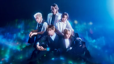STARGLOW's five members in coordinated formal styling against a blue aurora backdrop for WISHES