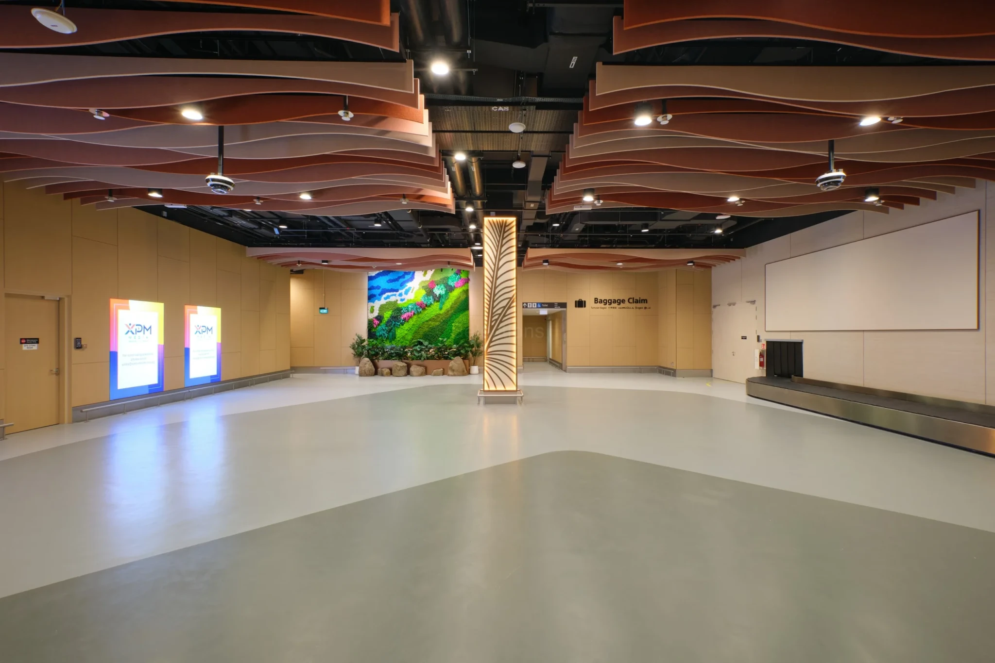 The baggage claim hall at the HarbourFront terminal, with curved wooden ceiling panels and digital kiosks