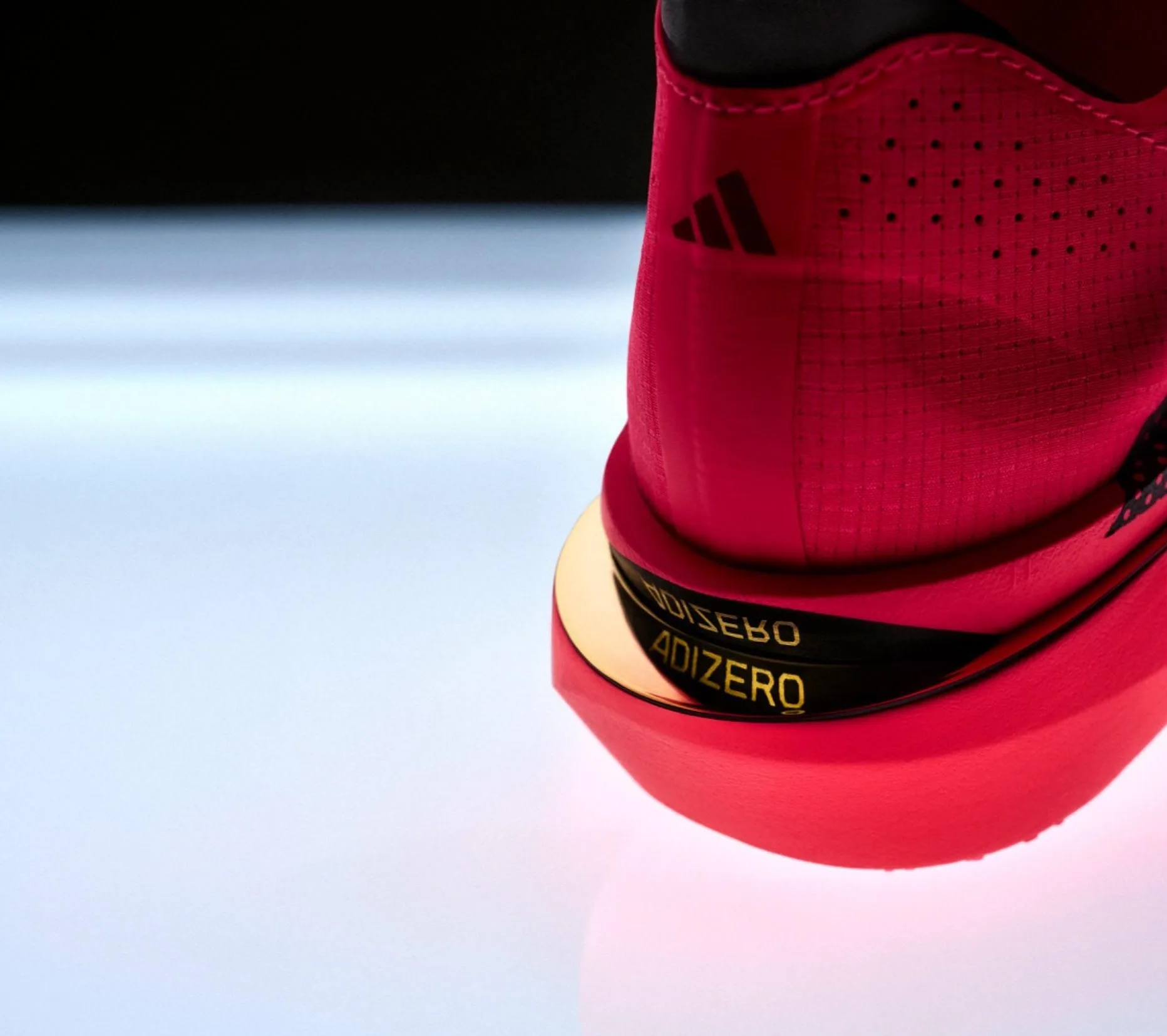 The Adizero Adios Pro 5 in red, showing its ventilated upper and Adizero heel label
