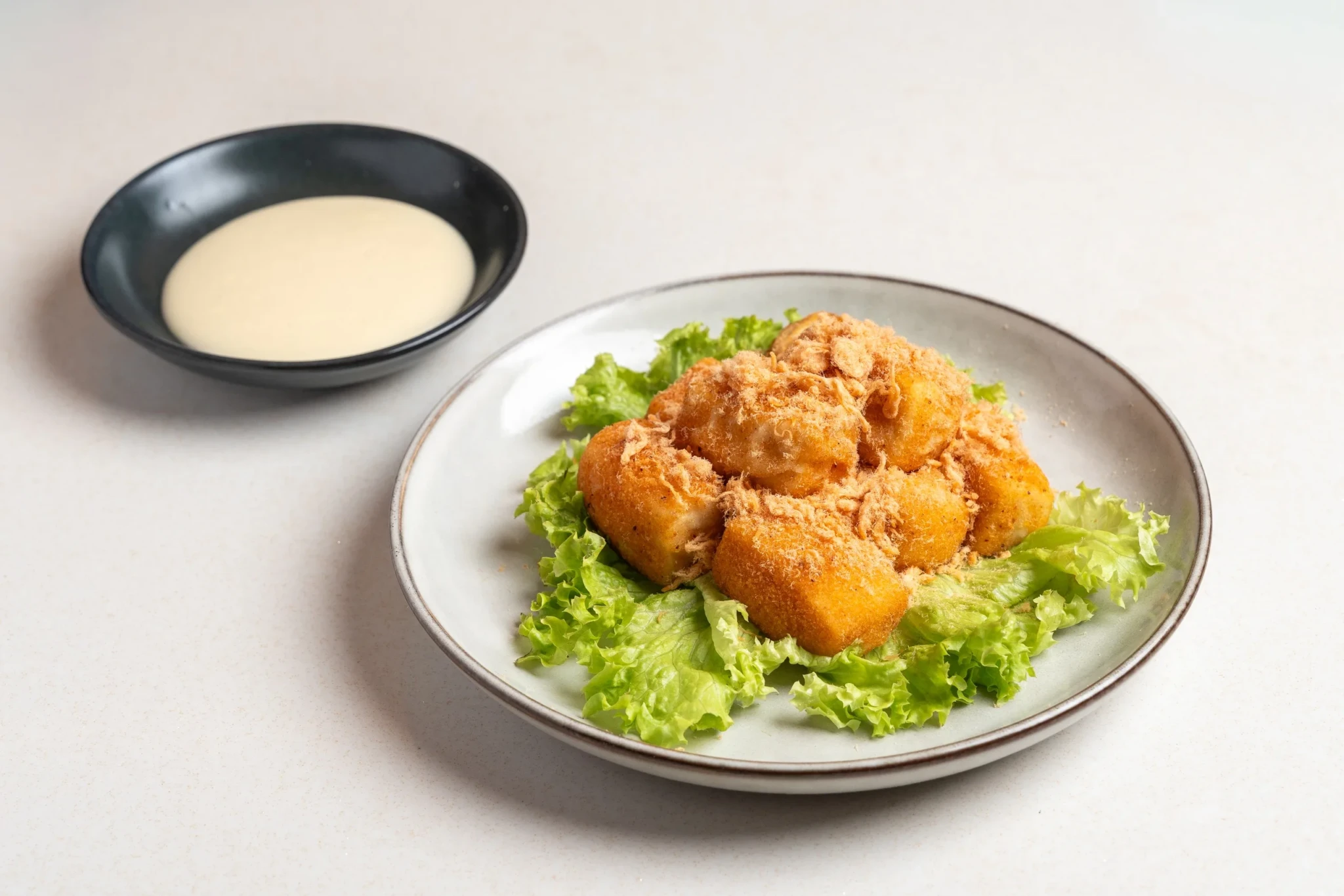 Crispy golden tofu cubes with salt and pepper seasoning on a bed of lettuce