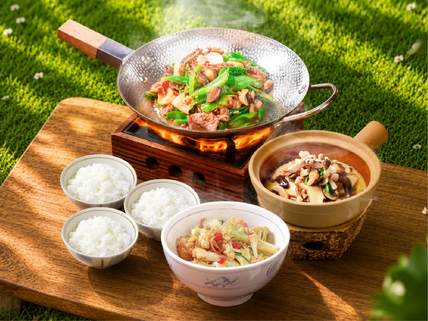 Meat and greens cooking in a wok at Yamamoto's Hamburg, with bowls of white rice alongside