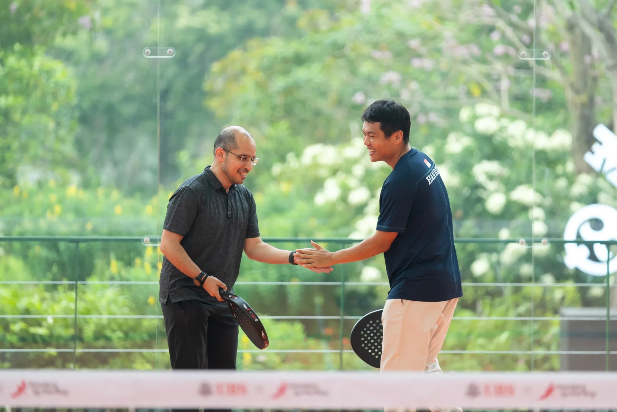 SPS Syed Harun Alhabsyi and National Padel Player Lim Han Ren greeting each other on court