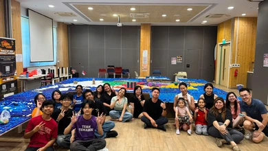 Sengkang East residents and youth volunteers seated in front of their bottle-cap map of Singapore