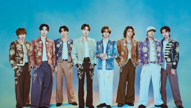 FANTASTICS posing in matching ornate jackets with floral embroidery against a blue background