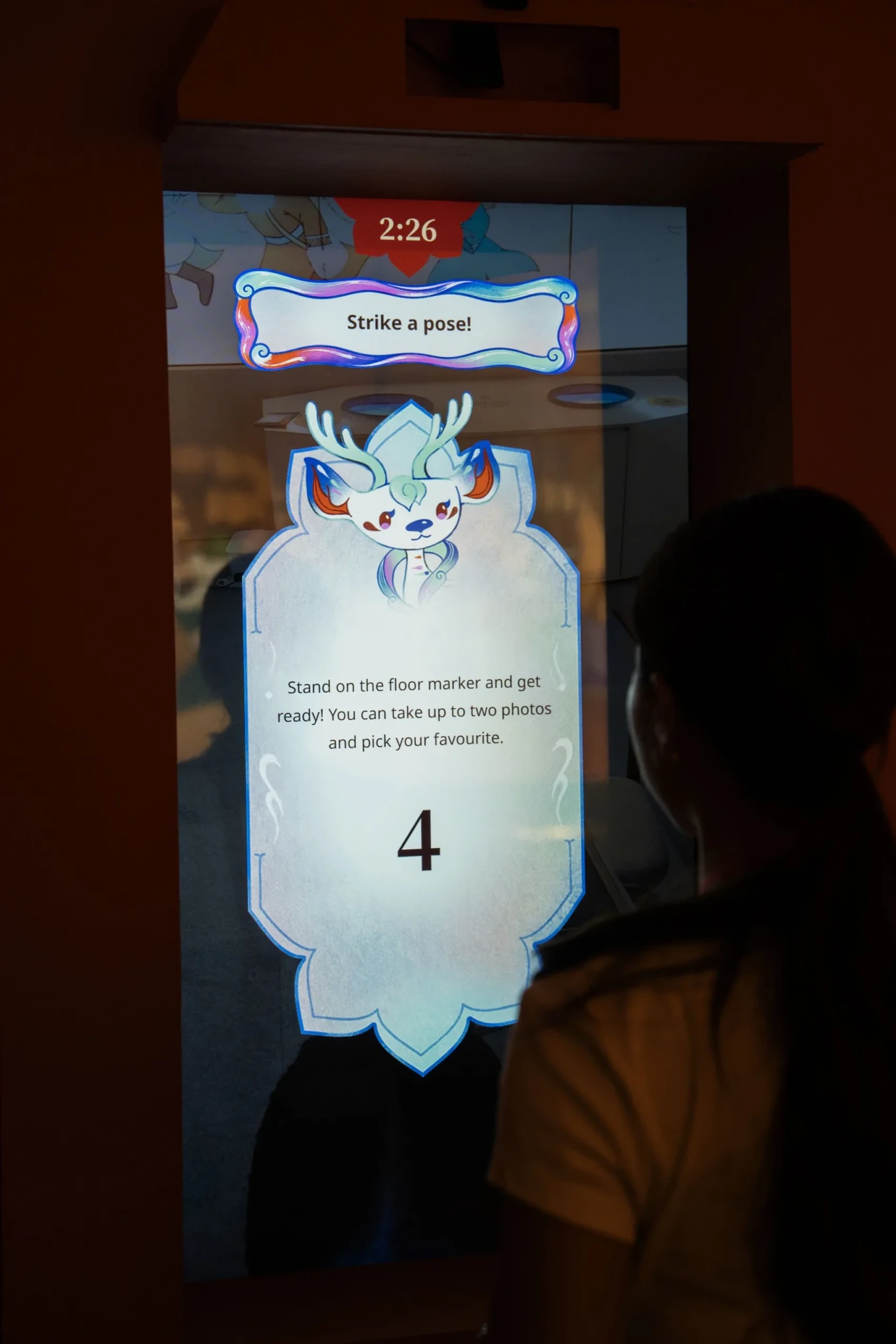 Interactive display prompting visitors to 'strike a pose' at the Cave of Colours photo booth