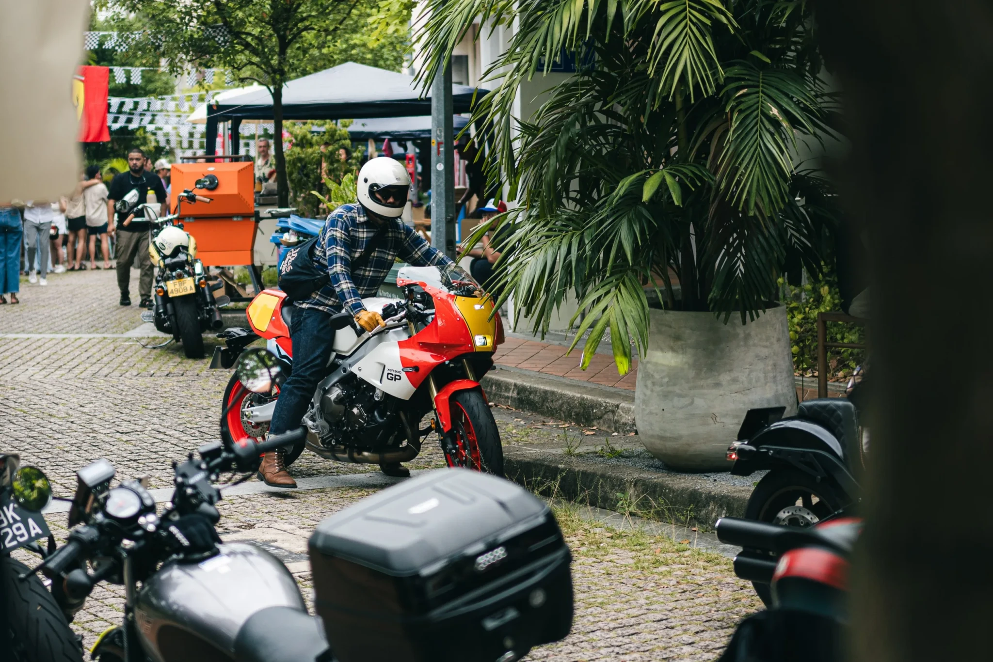 A motorcyclist on a red and white motorbike on Duxton Hill