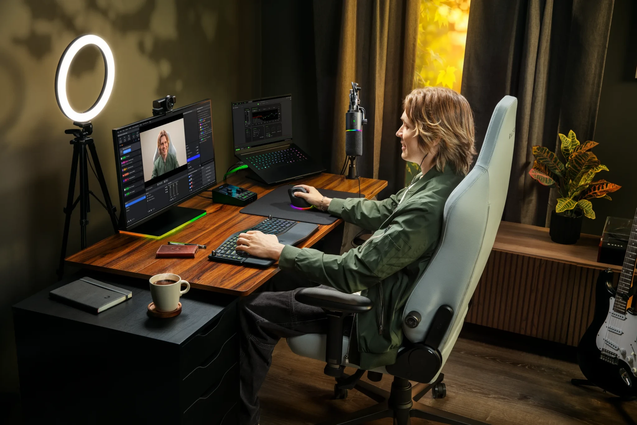 A musician streams at a desk with the Razer Kiyo V2 Pro webcam and Seiren V3 Pro microphone
