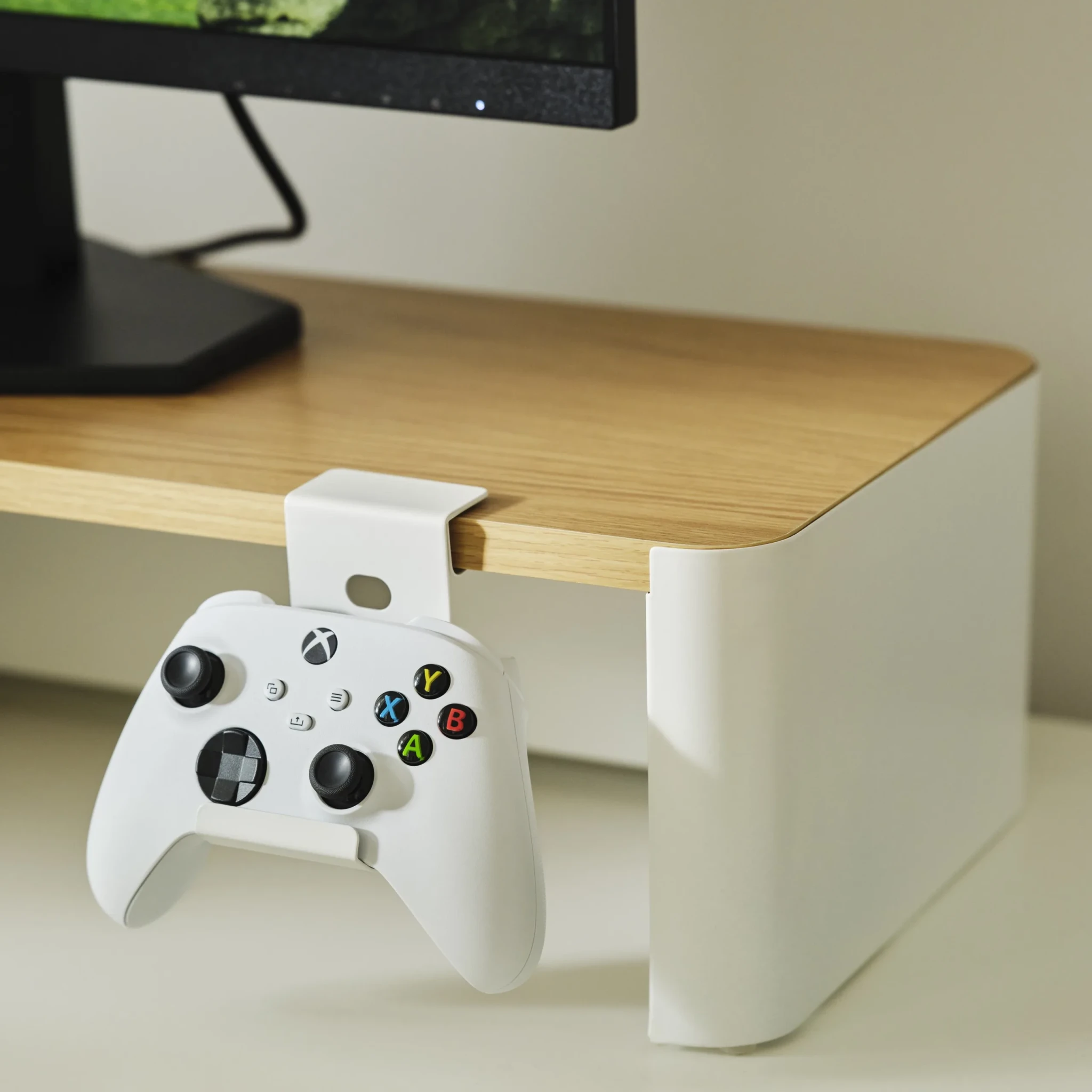YXSTABY Gaming monitor stand holding an Xbox controller on a wooden desk