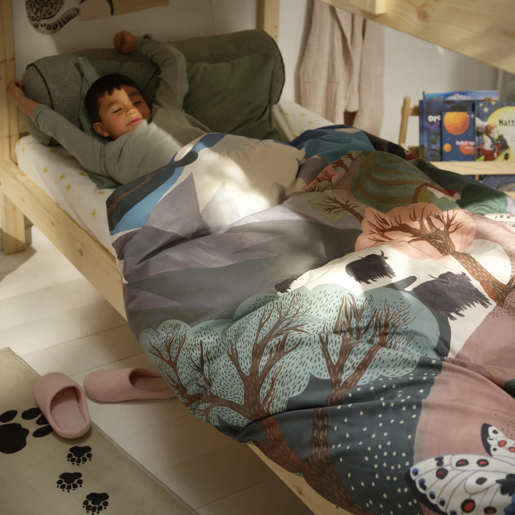 Child resting on the ALPTALL duvet cover and pillowcase