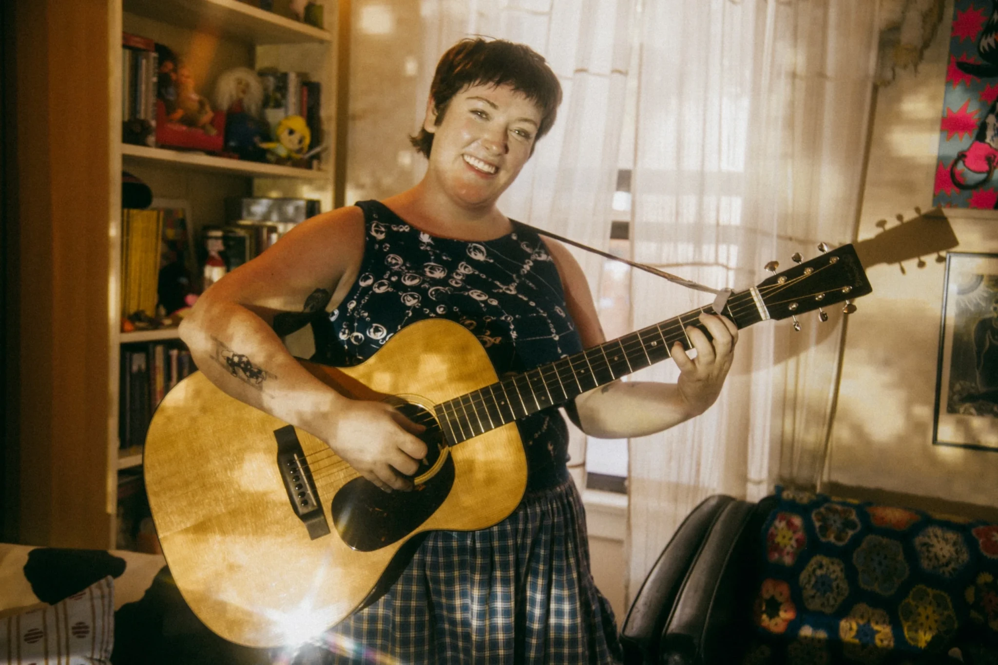 Melody Stolpp of Sweetbreads sitting at home with an acoustic guitar