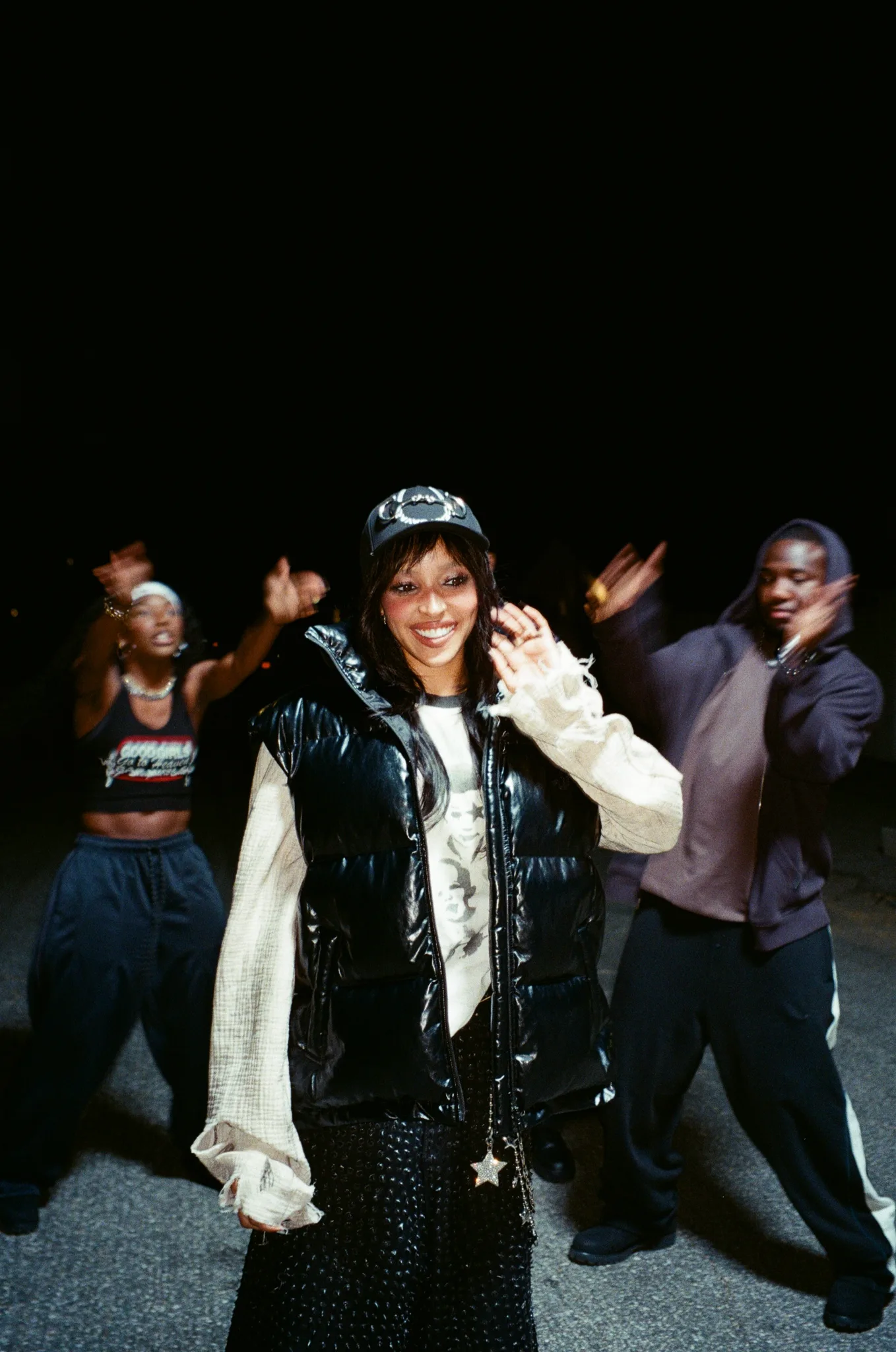 Tinashe in a black vinyl vest and sequined pants with backing dancers