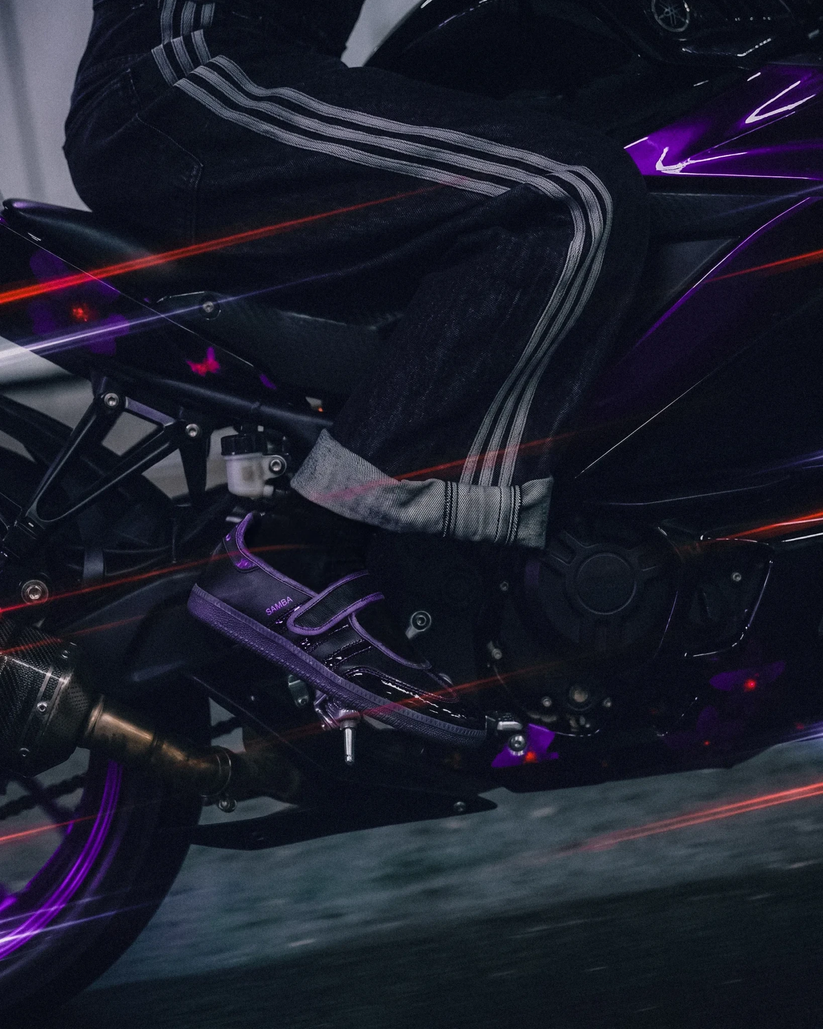A person wearing the Black Orchid Samba Jane under neon purple and red lighting