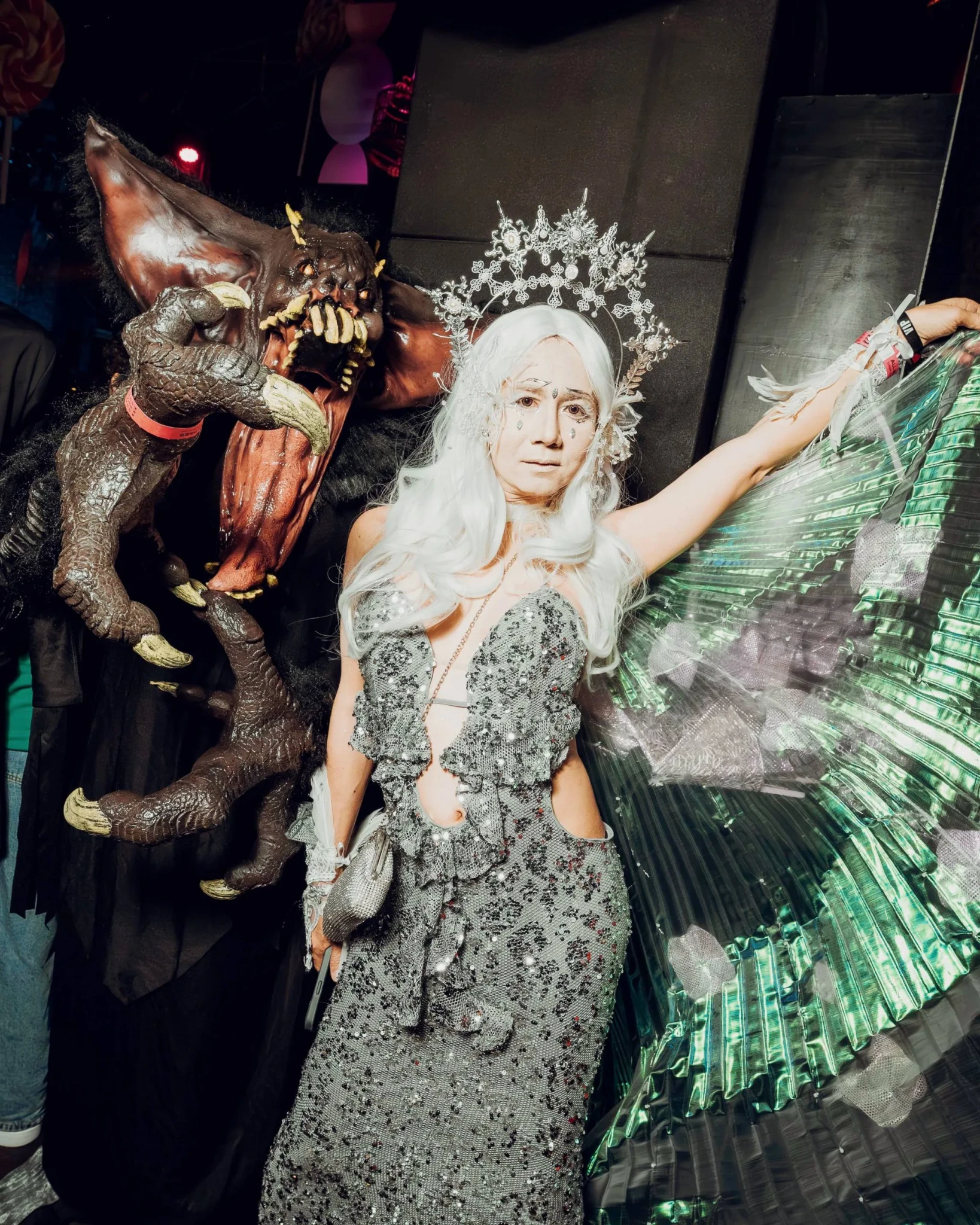 A costumed guest posing with a monster puppet and mechanical wings