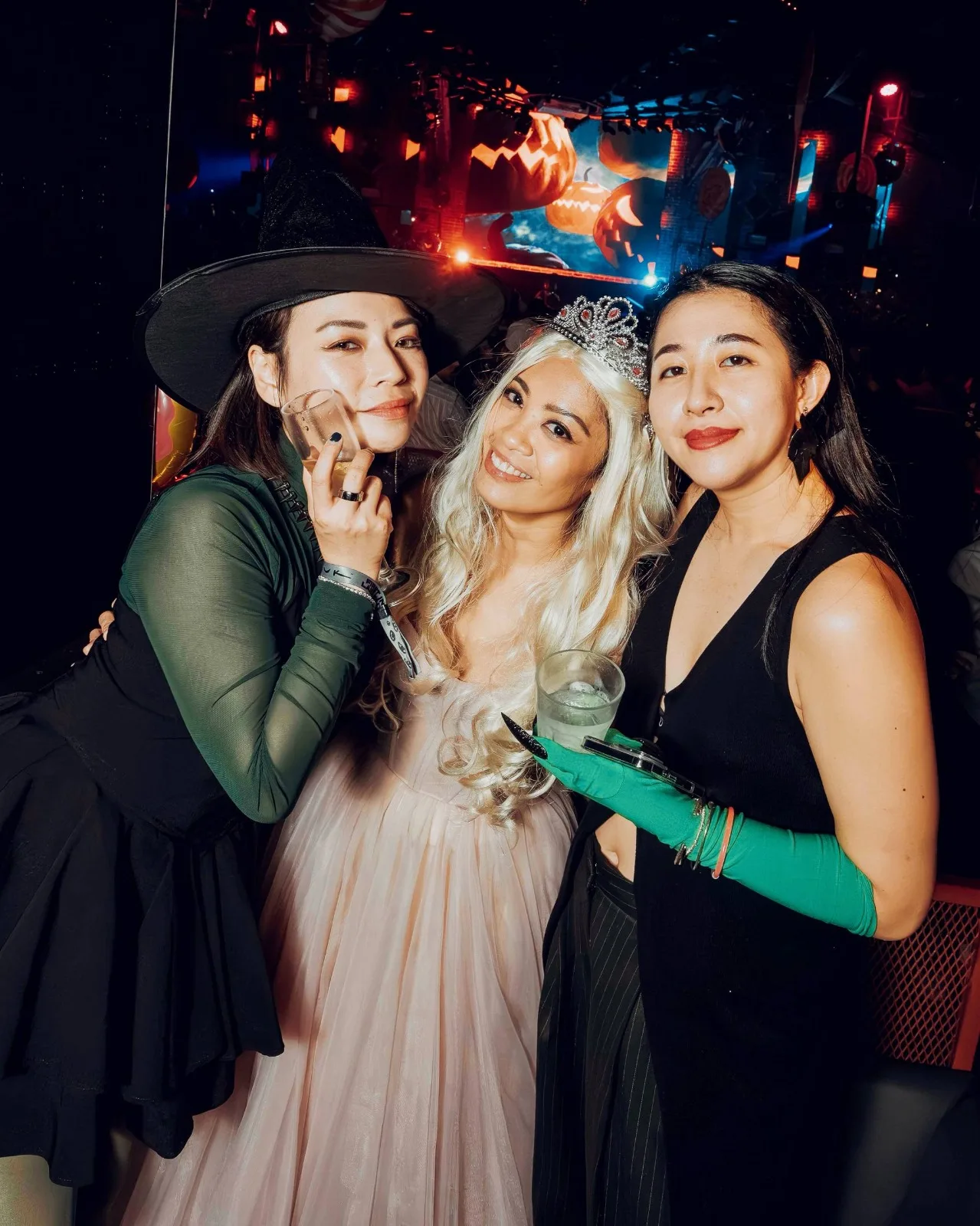 Three costumed guests, one in a tiara and pale tulle dress