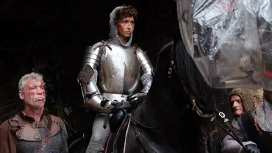 Three figures in medieval armour and chainmail stand in a row