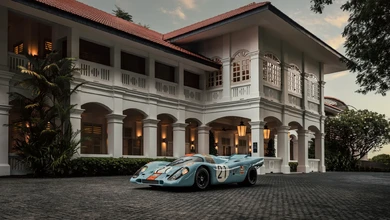 The 1971 Porsche 917 KH parked in front of a colonial-style building in Singapore