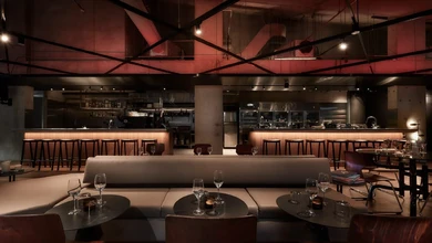 Third Floor's bar and dining room with a red ceiling, curved banquettes, and an open kitchen