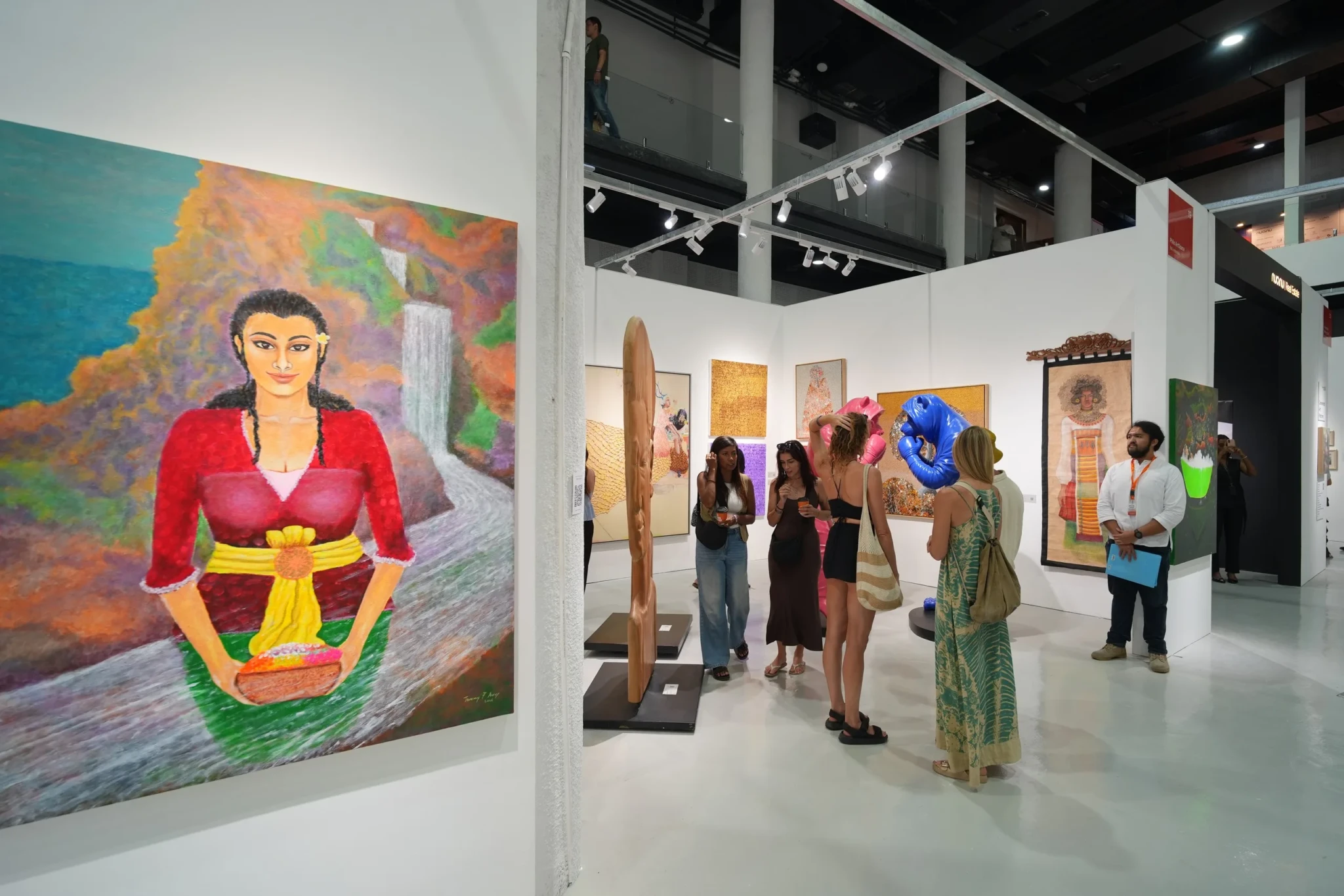 Visitors studying a colourful portrait on a gallery wall at Art & Bali 2026
