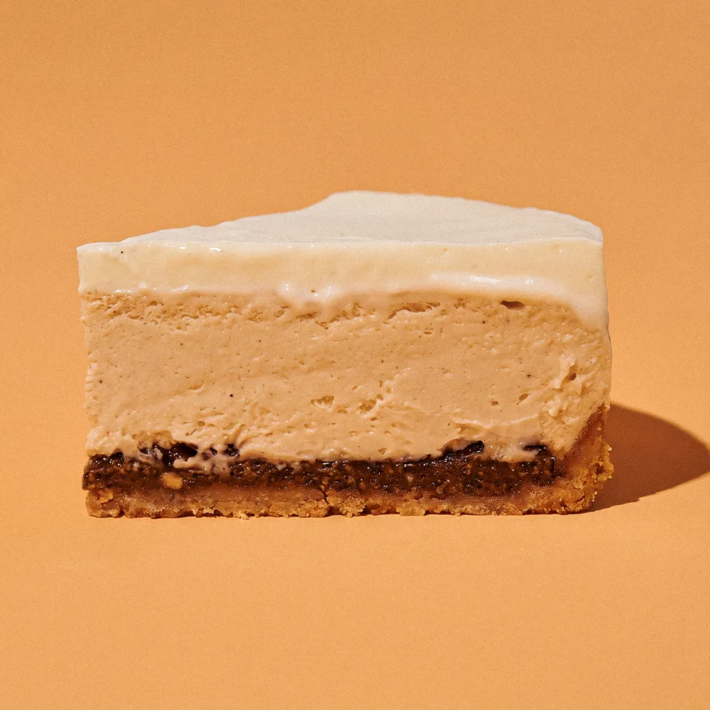 A single slice of The Latte Cheesecake showing its almond crumble, coffee praline, cheesecake and mascarpone mousse layers