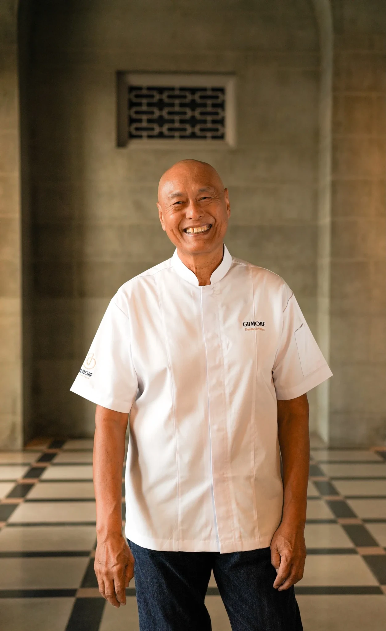 Chef Damian D'Silva smiling in the dining room of Gilmore & Damian D'Silva