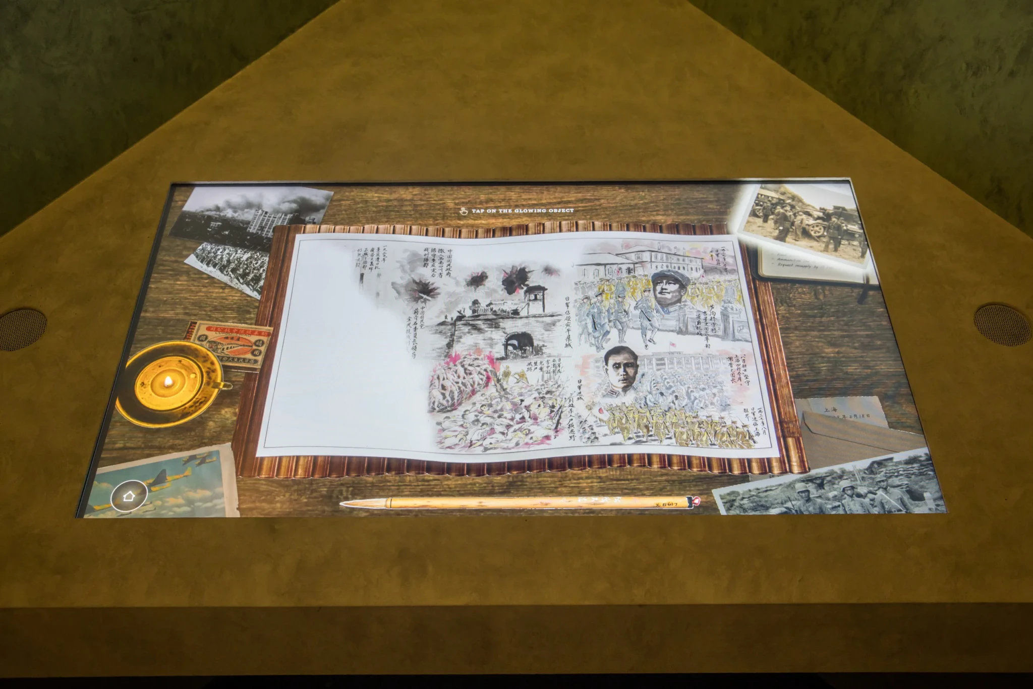 Tan Chong Tee's illustrated scroll of the Sino-Japanese War with a compass and period photographs on a wooden surface