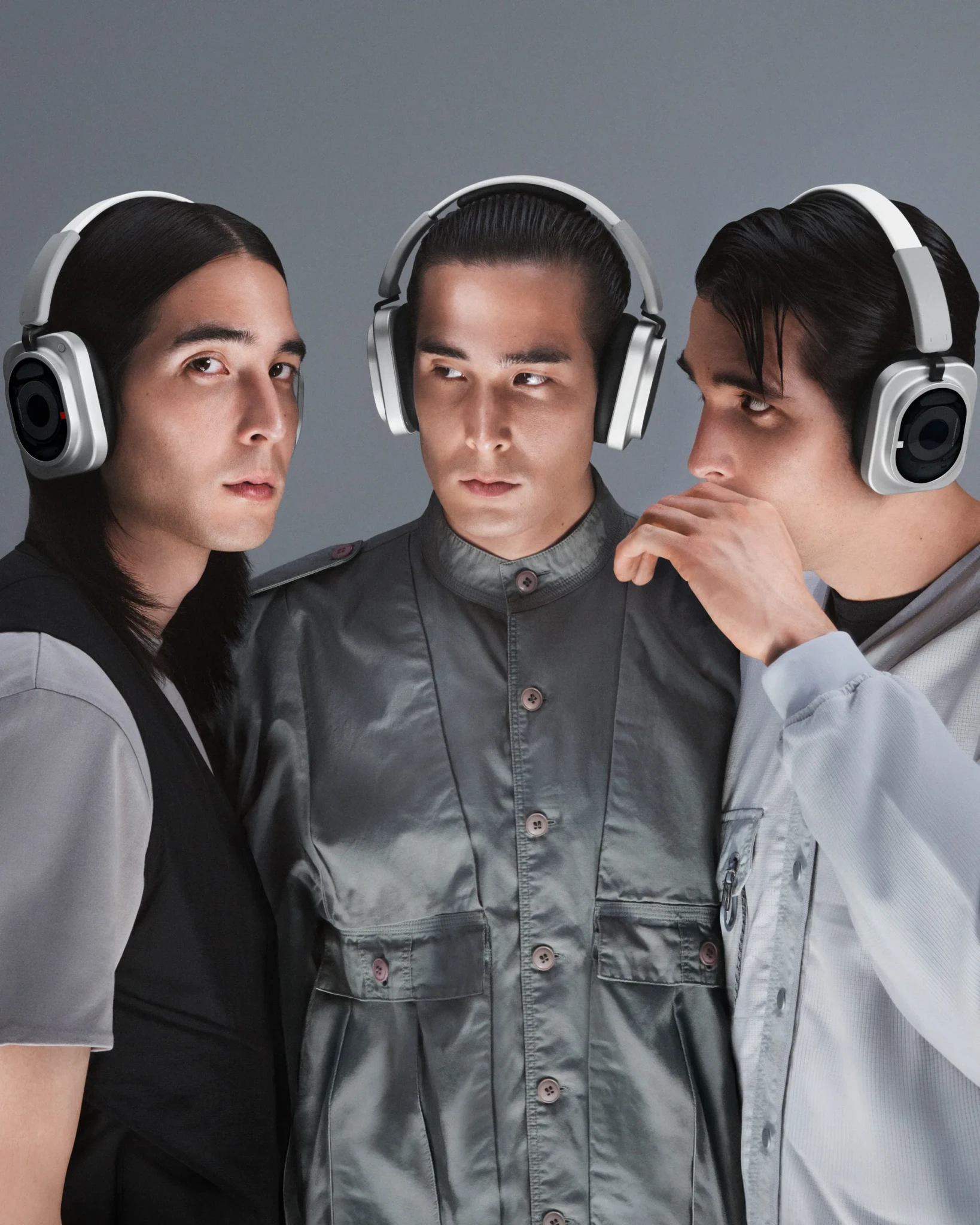 Three models wearing white Nothing Headphone (1) Pro against a grey backdrop