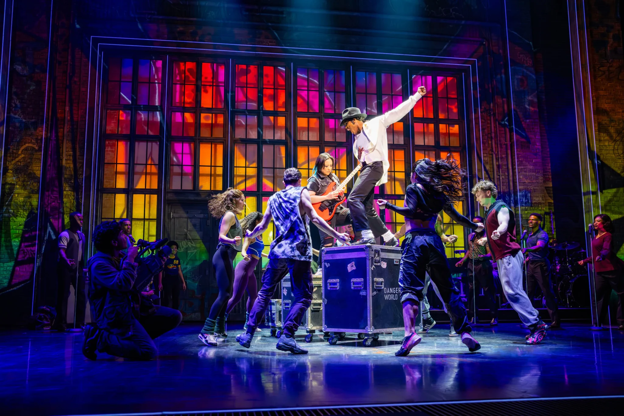 Dancers and musicians perform energetic choreography in MJ THE MICHAEL JACKSON MUSICAL under colorful stage lighting