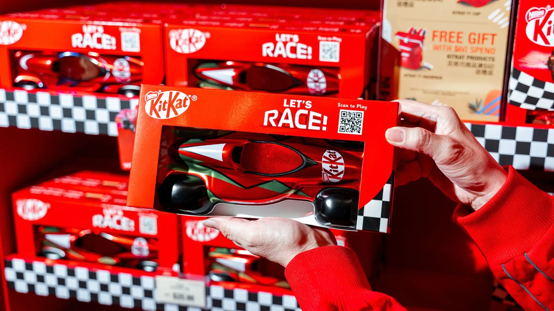 Red KitKat racing edition packaging with LET'S RACE branding held in hands