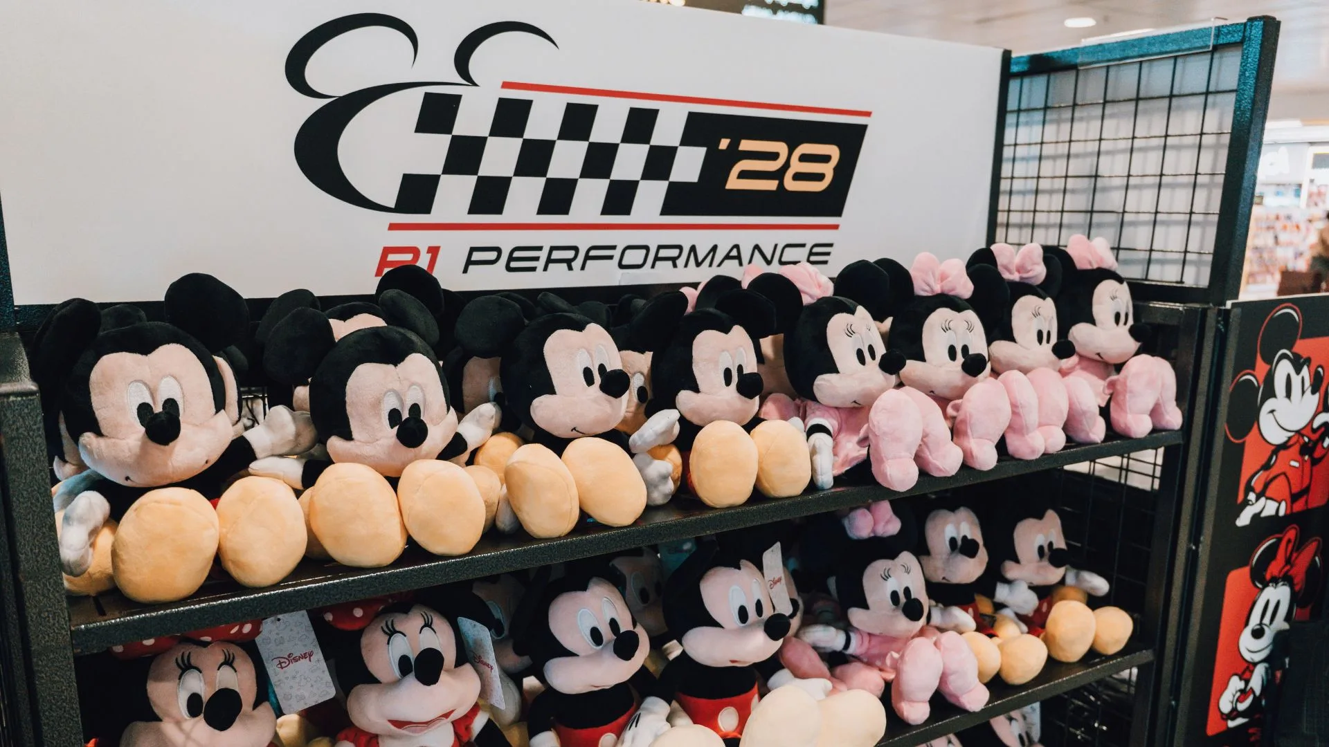 Mickey and friends plush toys in racing gear on display shelves