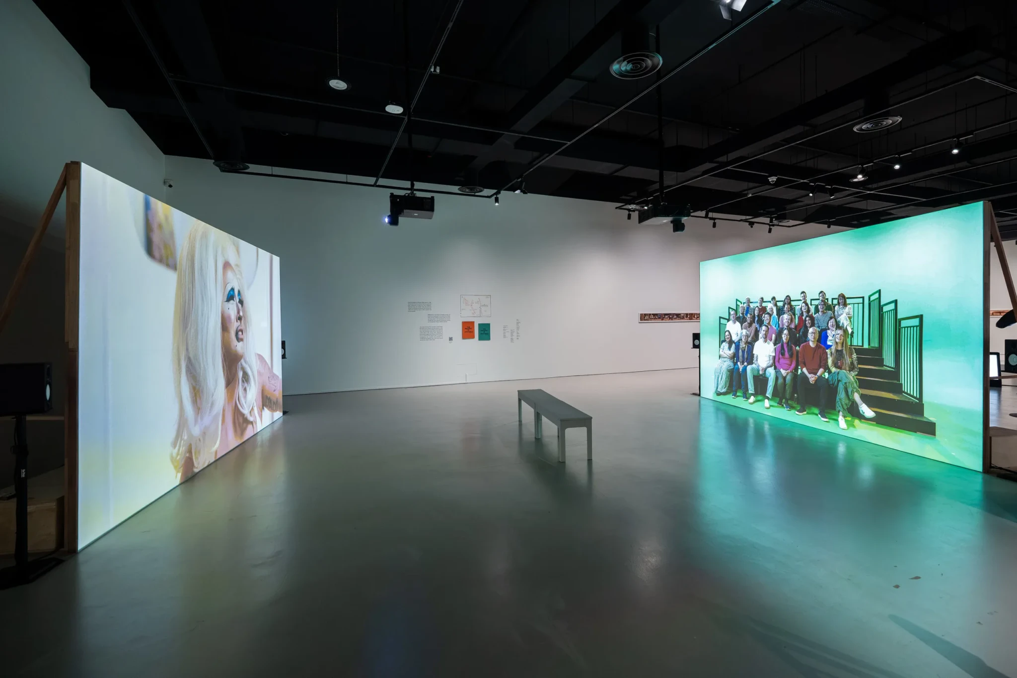 Large video screens showing Sin Wai Kin's The Time of Our Lives in the Singapore Art Museum gallery
