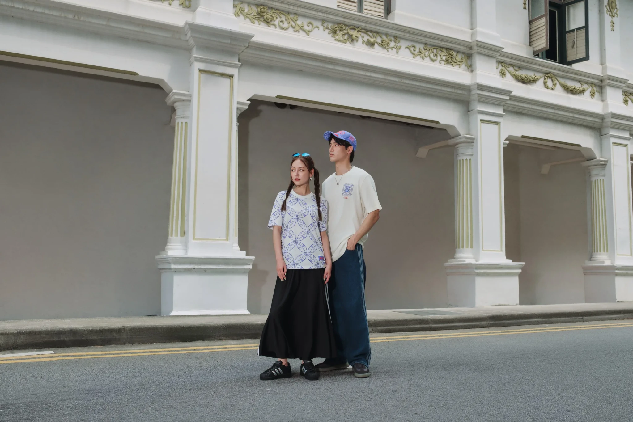 Two people in adidas x Audi Revolut F1 Team apparel outside Funan's neoclassical building