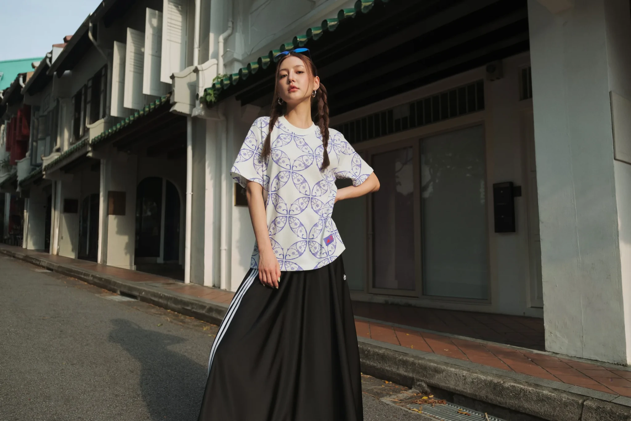 Model in an adidas x Audi Revolut F1 Team tee with a purple geometric print and black track pants at Funan