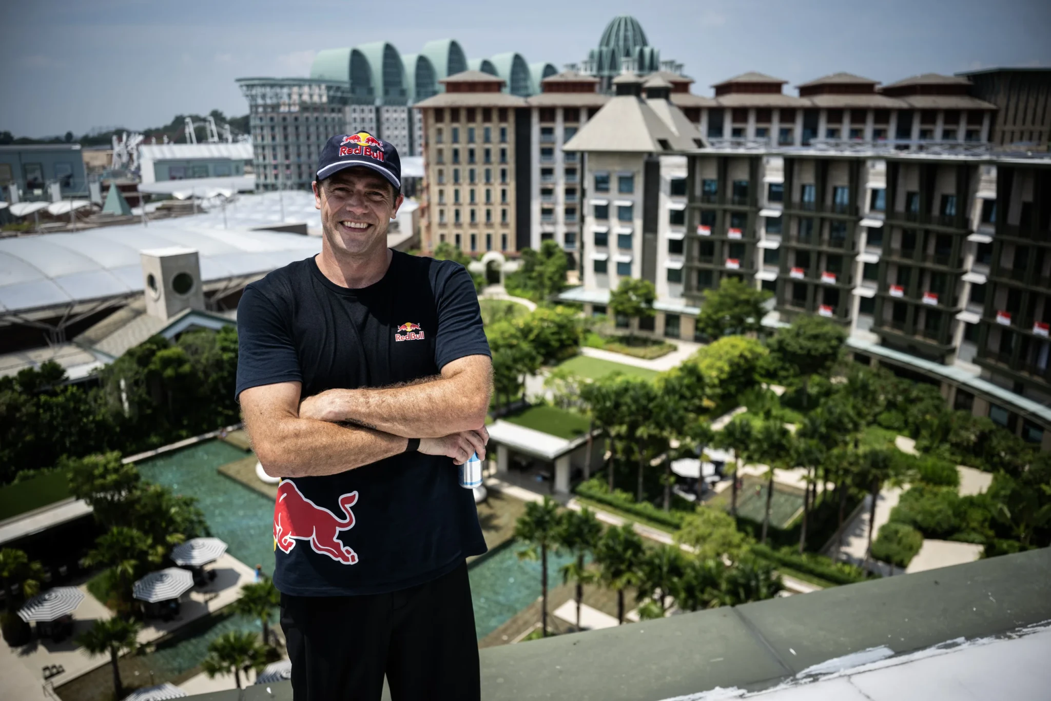 A Red Bull freerunner posing on a rooftop above Resorts World Sentosa
