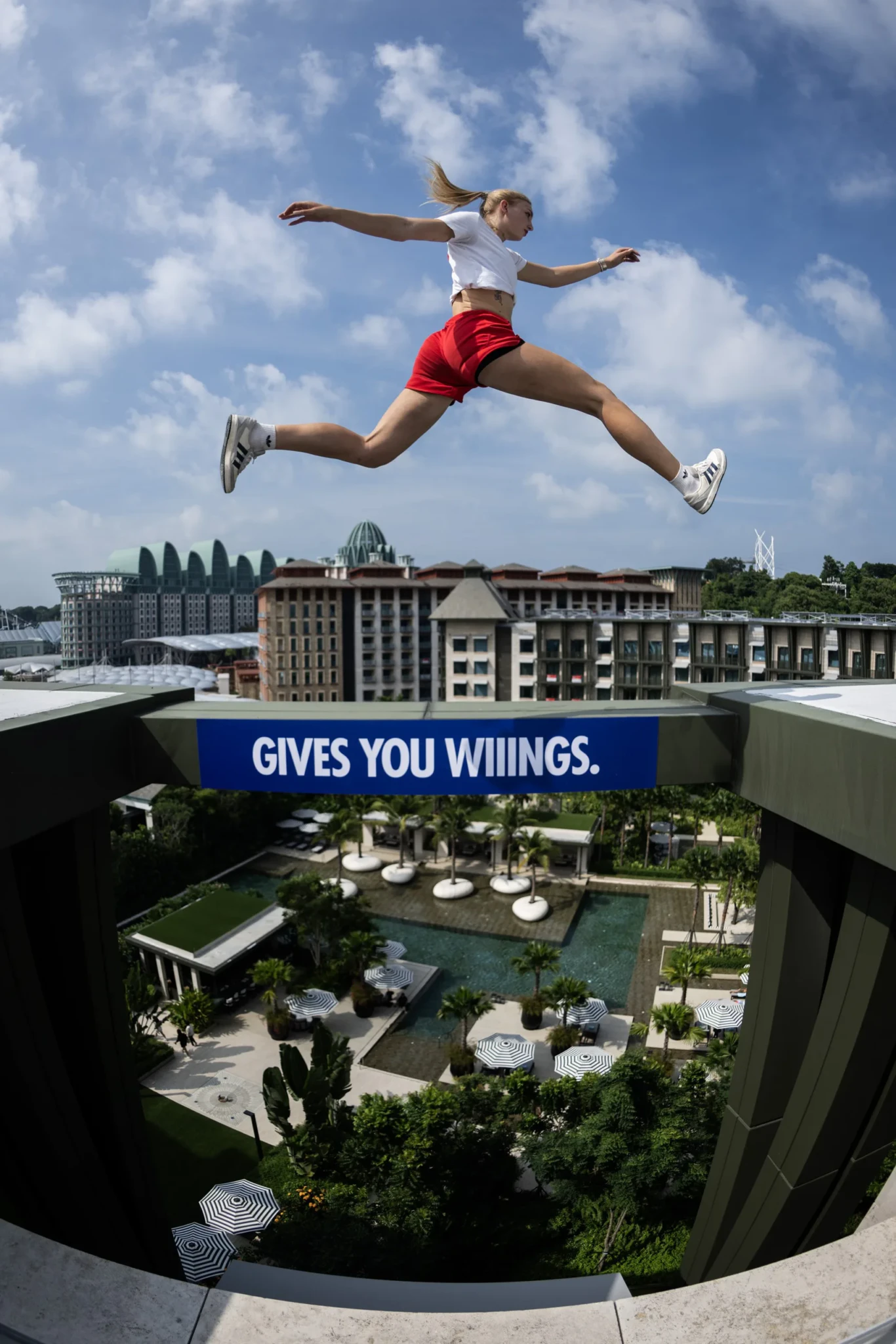 A freerunner jumps a rooftop gap with Resorts World Sentosa and the Singapore skyline below