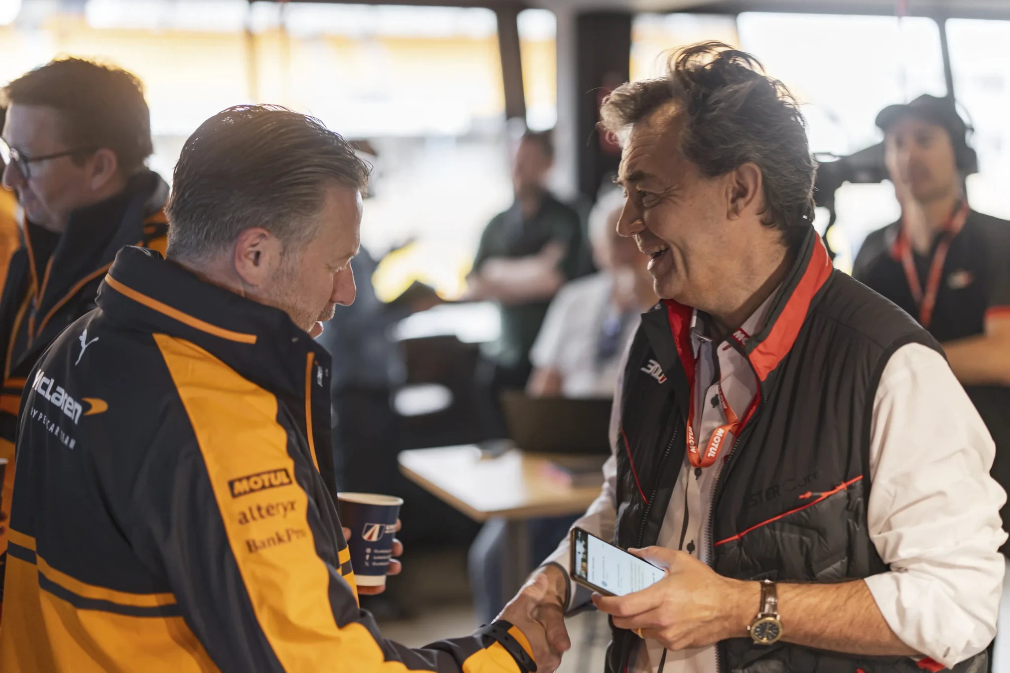 A McLaren Racing team member talks with a Motul representative
