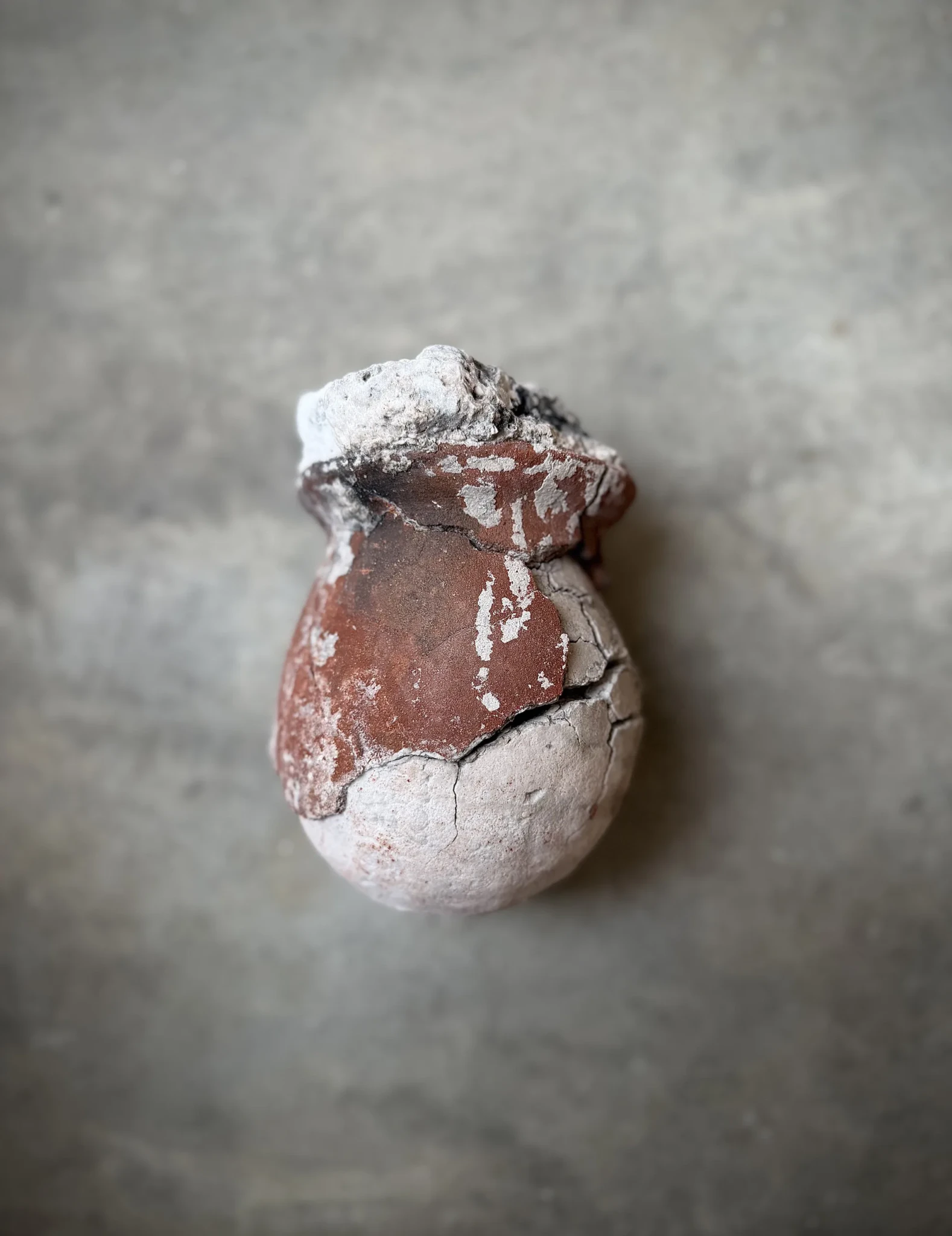 Asín Tibuok salt with a reddish-brown centre and white powdery coating against a grey background