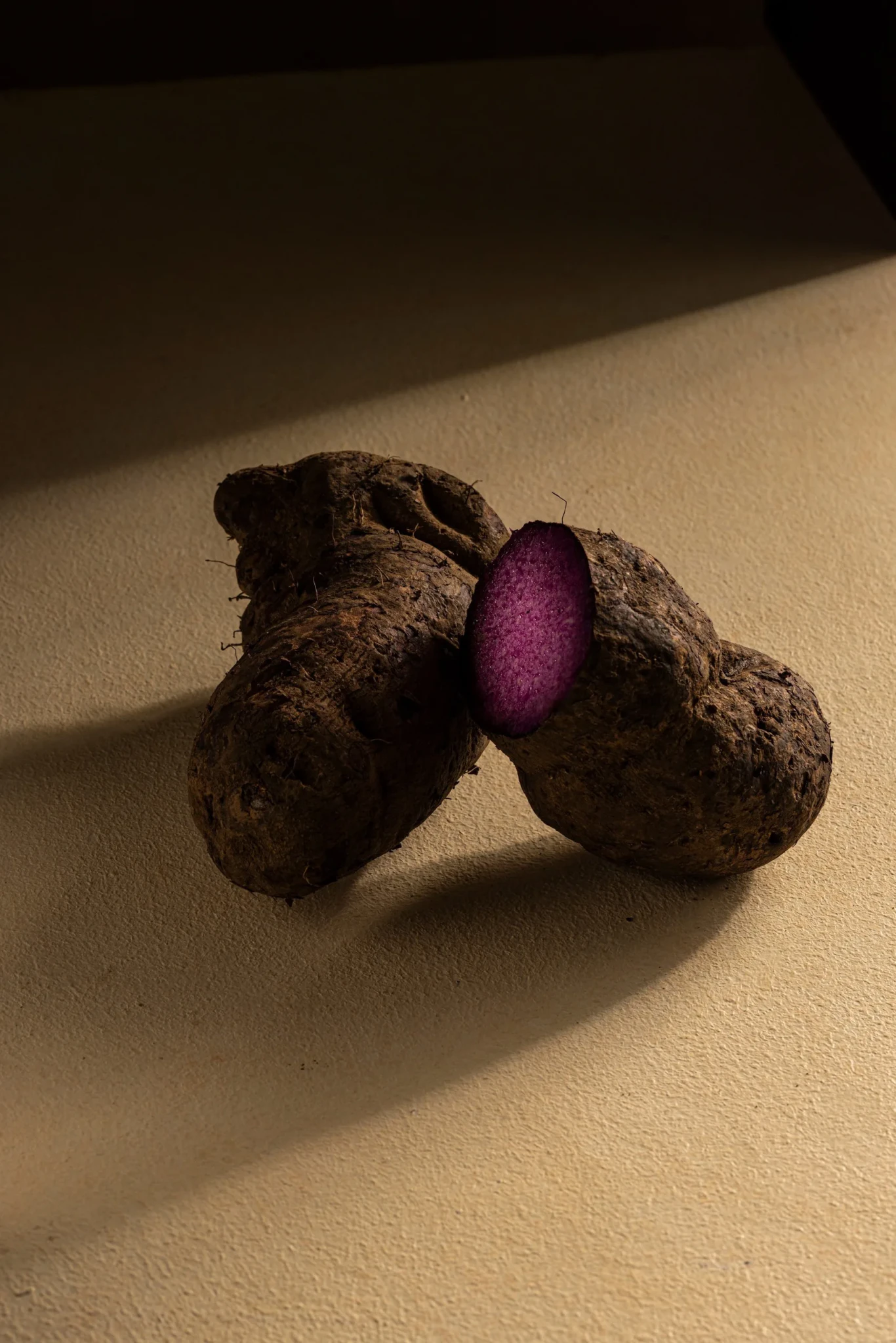 Whole and halved ube showing its deep purple flesh