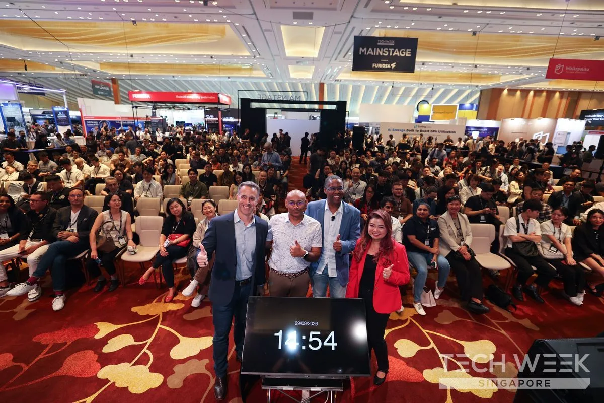 Four people give a thumbs-up in front of a seated crowd under the Mainstage sign at Tech Week Singapore 2026