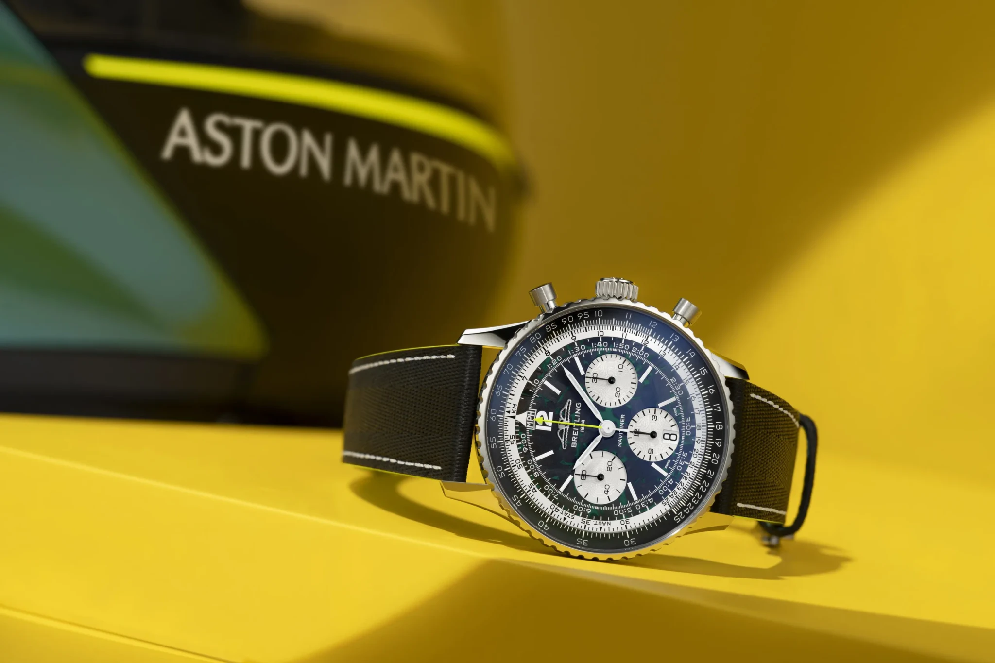 Breitling chronograph watch on yellow Aston Martin background