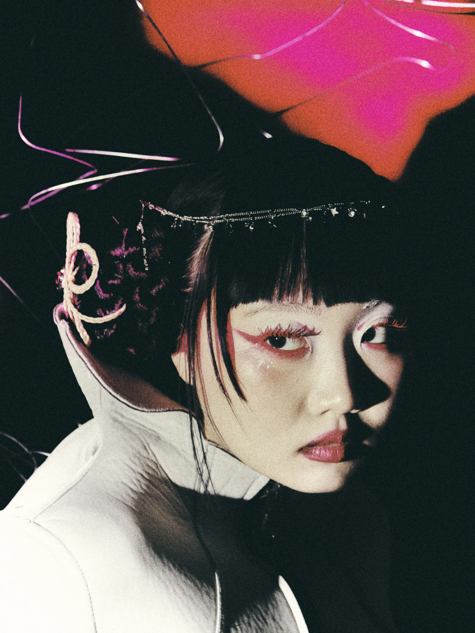 ena mori in a portrait lit in neon pink and orange