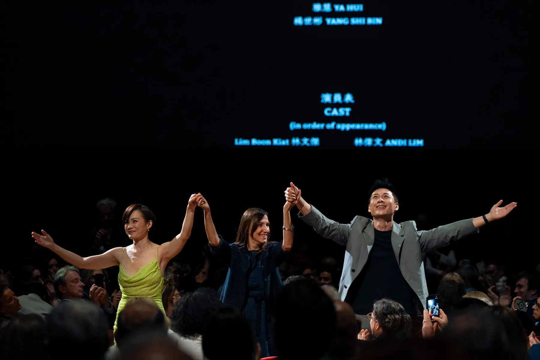 Anthony Chen and Yeo Yann Yann celebrate on stage with raised arms