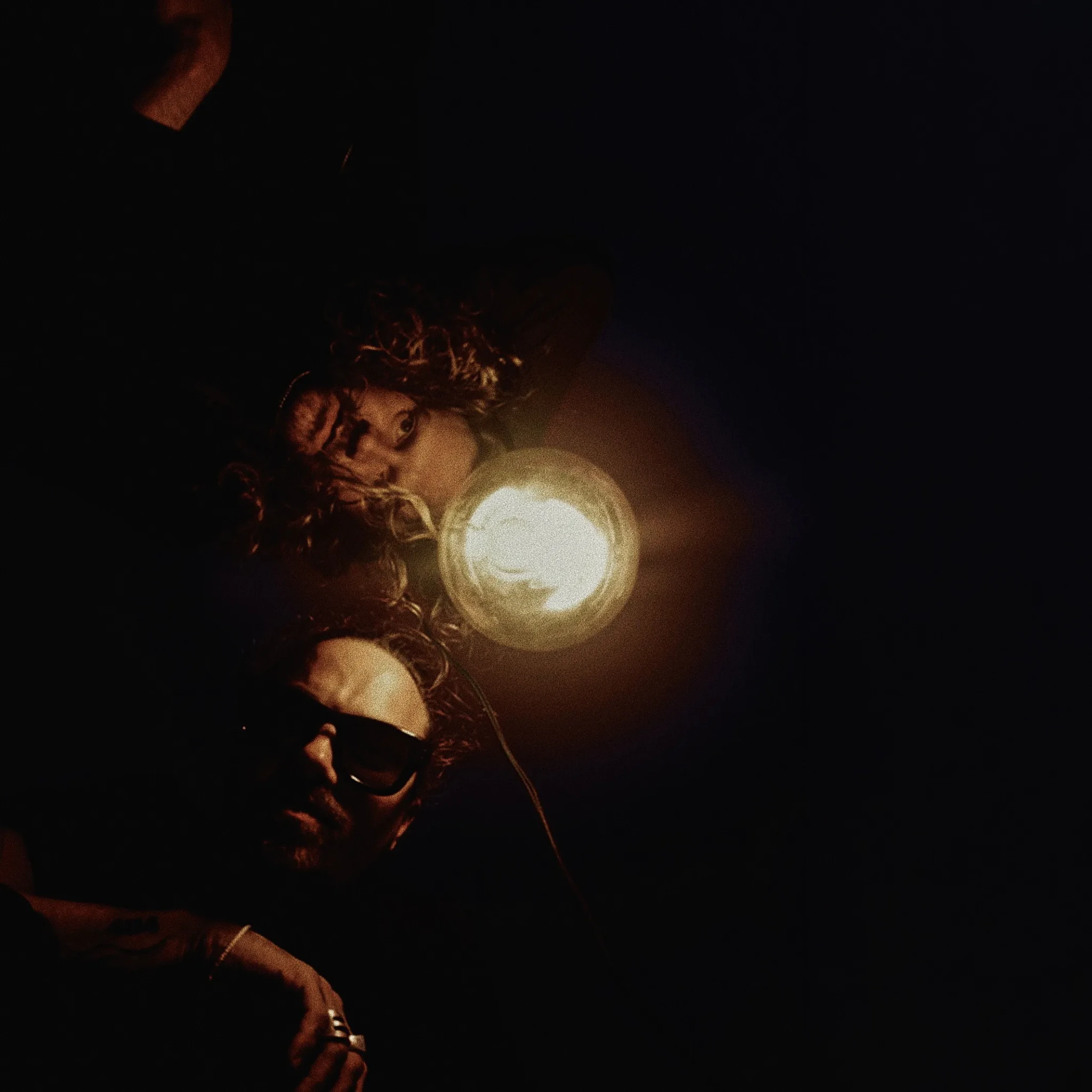 A hand holding up a glowing orb of light against a dark background