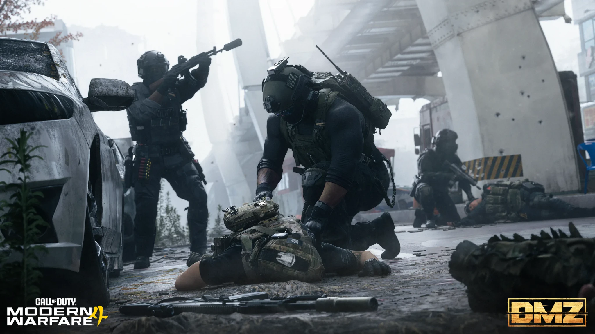 An operator kneeling to loot a downed soldier's backpack while a squadmate covers with a suppressed rifle beneath an overpass