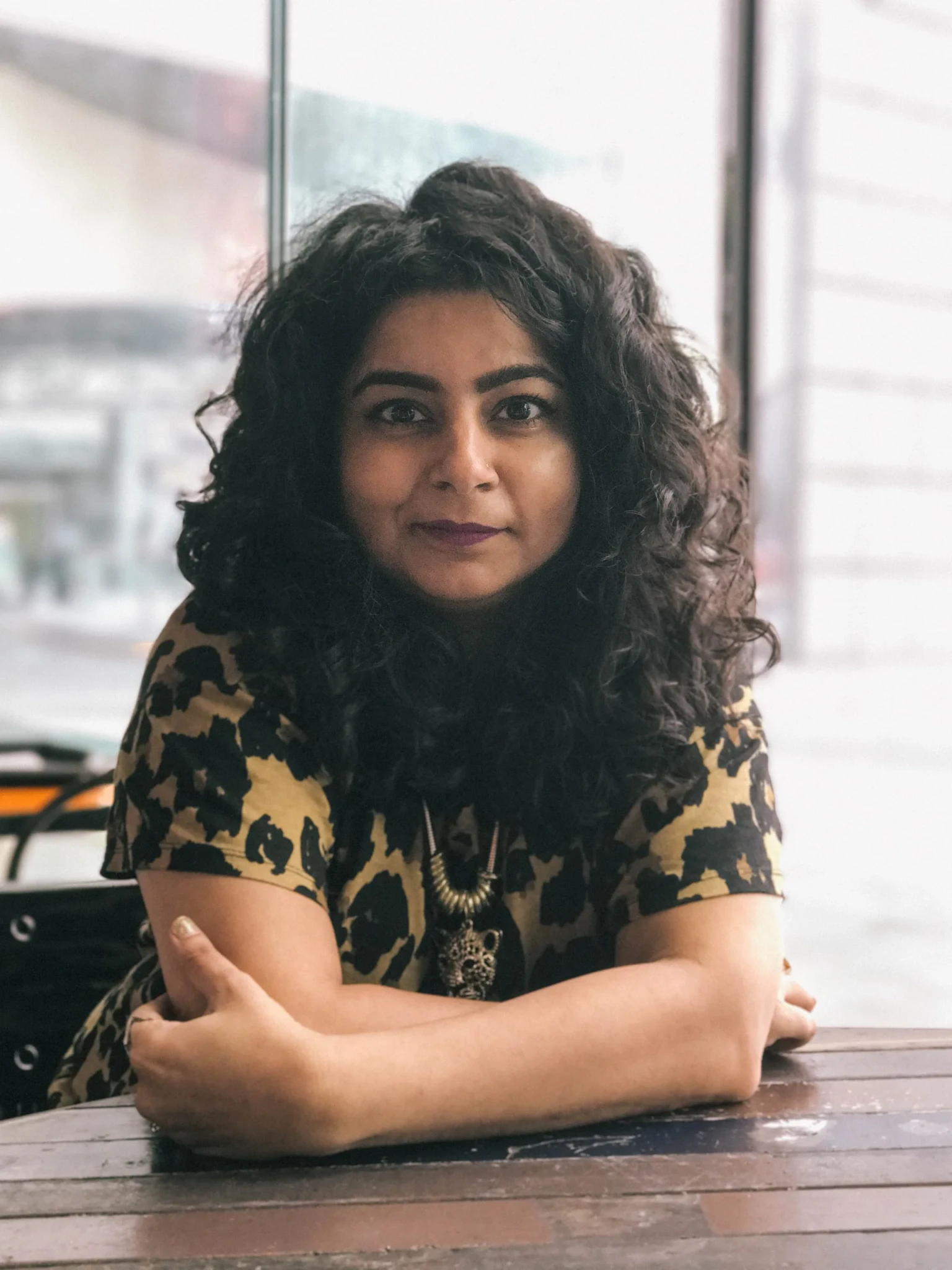 Pooja Nansi pictured at a high-rise venue with city views behind her