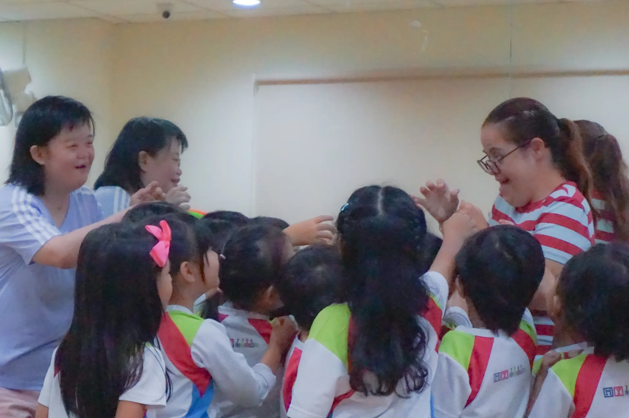 Trainers work with a group of preschool-age children in a classroom