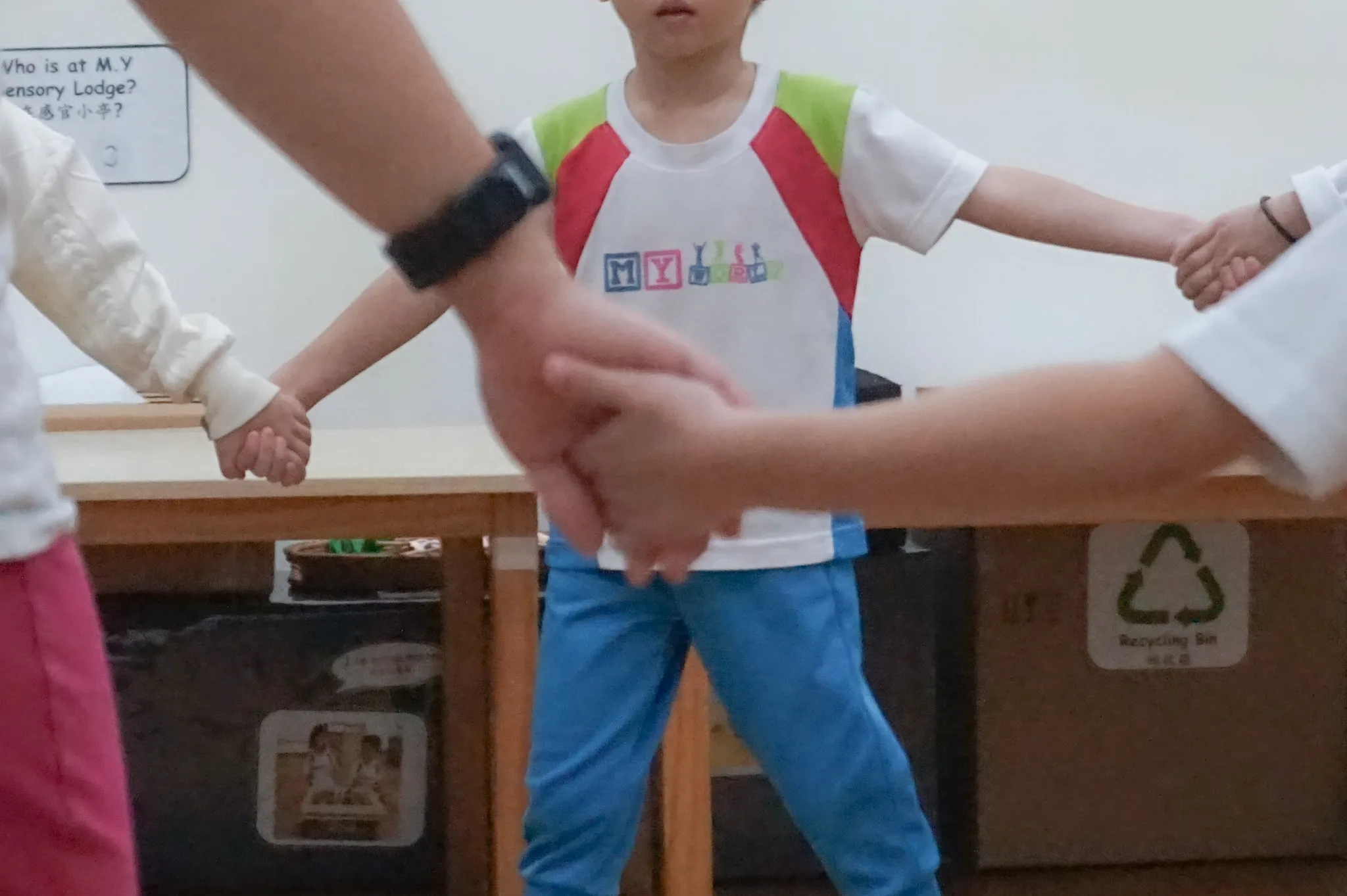 Preschoolers work together on a wooden hands-on learning activity in a classroom